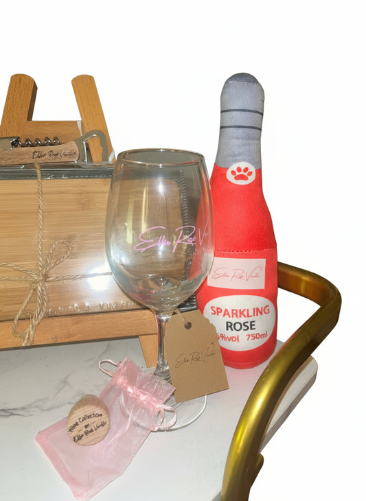 Bottle of Sparkling Rosé and a glass on a table with a chair in the background.